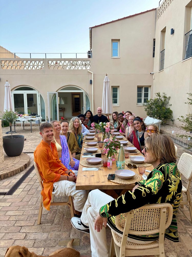 Guests sharing dinner in the courtyard at Savi Coliving
